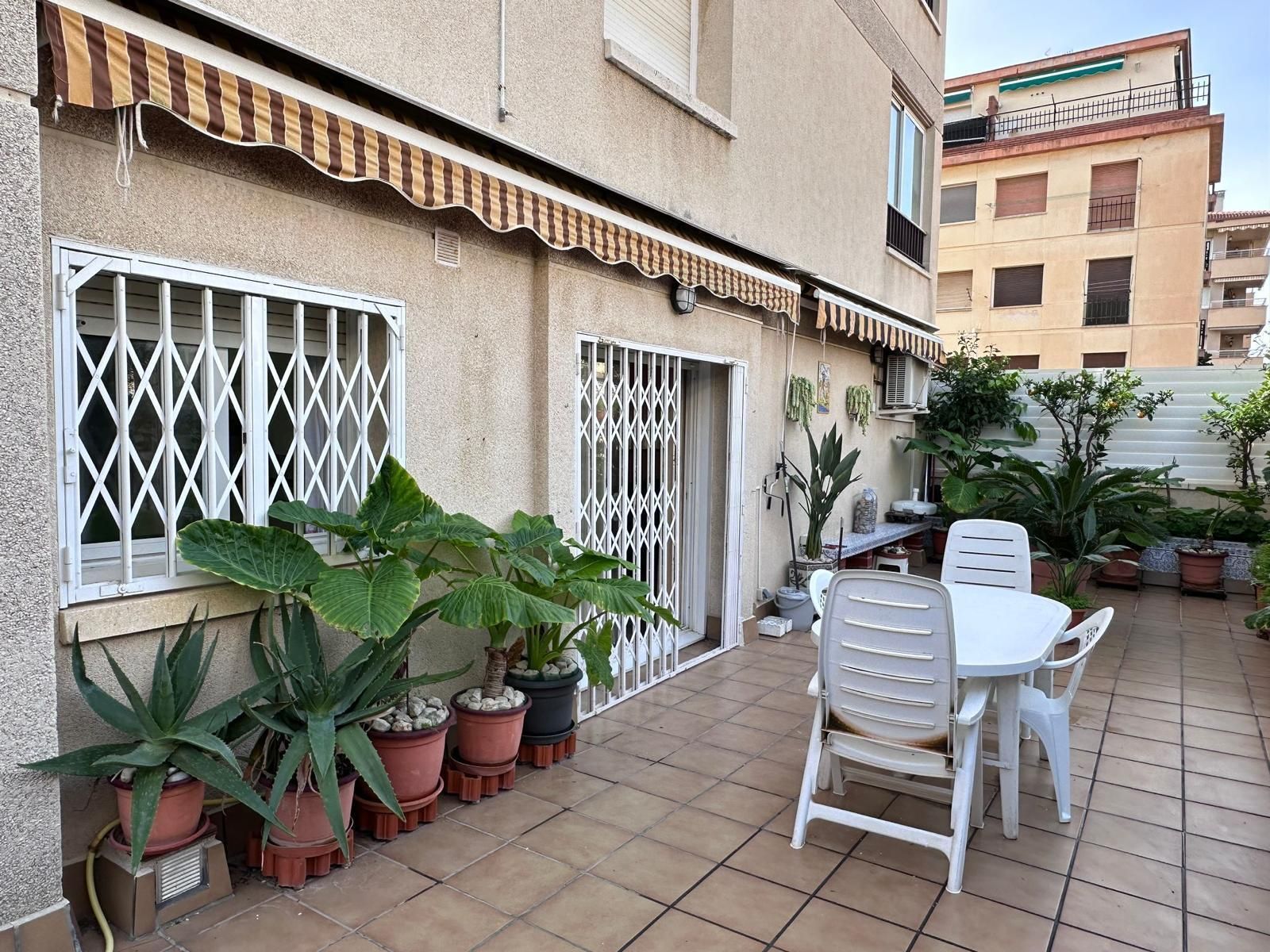 Un patio con una mesa y sillas frente a un edificio.