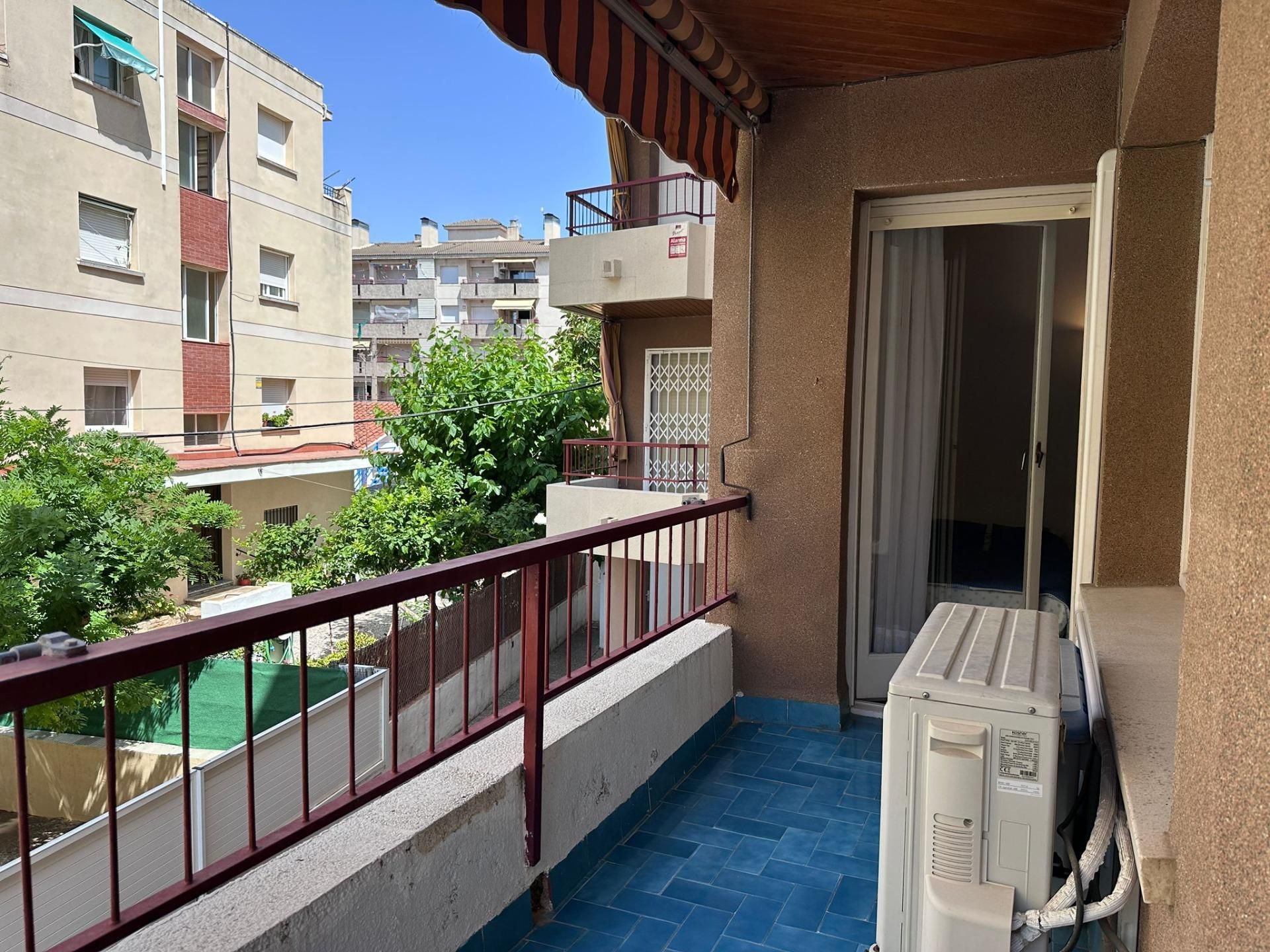 Un balcón con un toldo rojo y blanco.