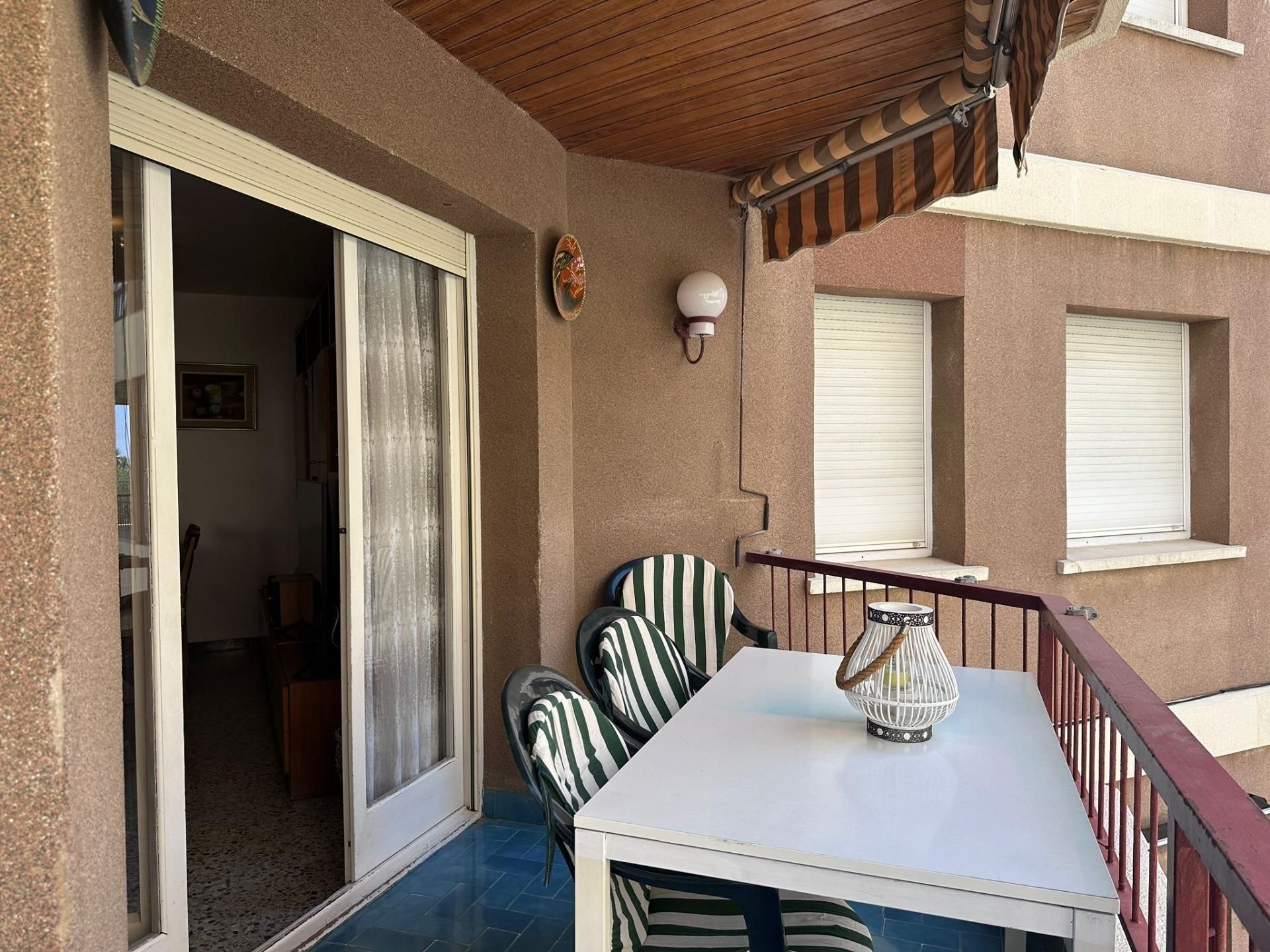 Un balcón con una mesa y sillas.