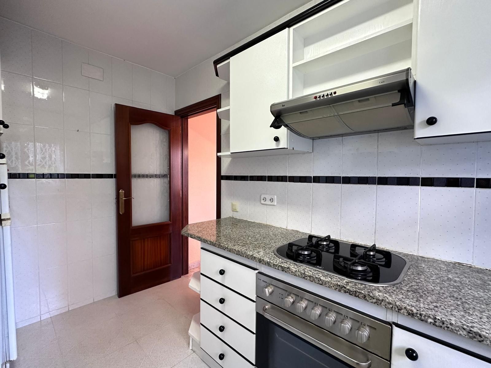 Una cocina con gabinetes blancos y un horno de estufa.