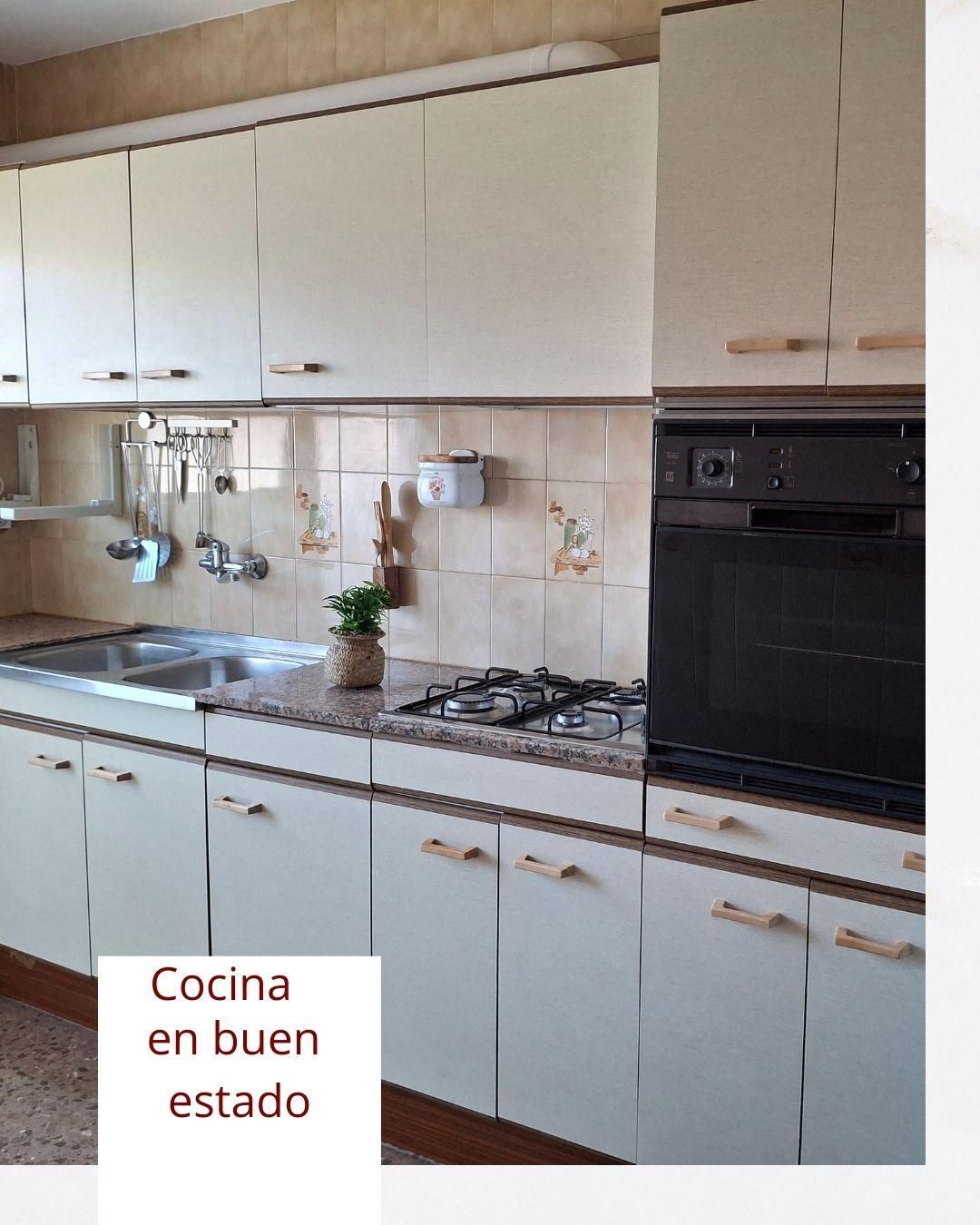 A kitchen with white cabinets and a sign that says cocina en buen estado