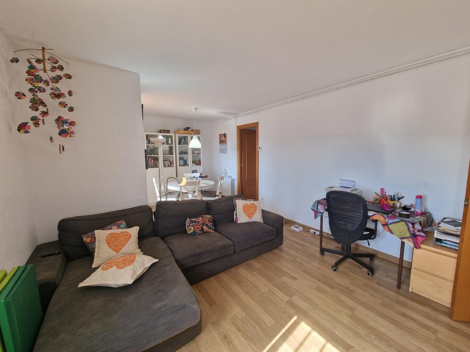 Una sala de estar con sofá, escritorio y silla.