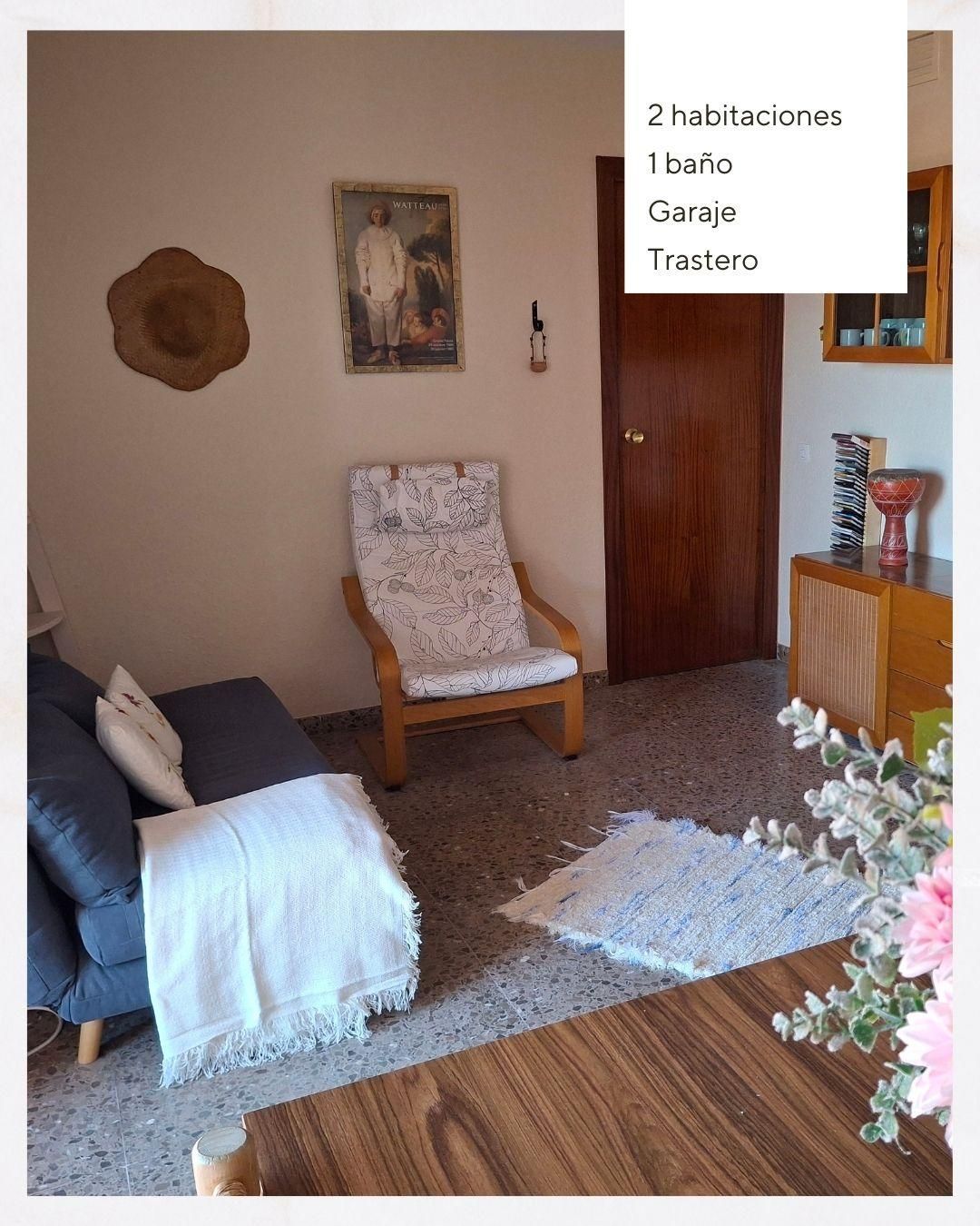 Una sala de estar con un sofá, una silla y una mesa.