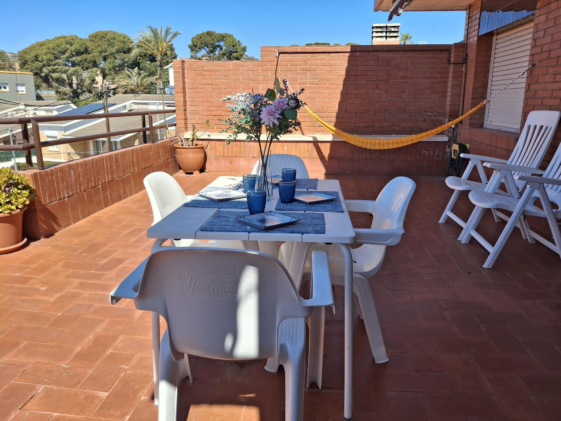 Un patio con mesa y sillas y una hamaca.