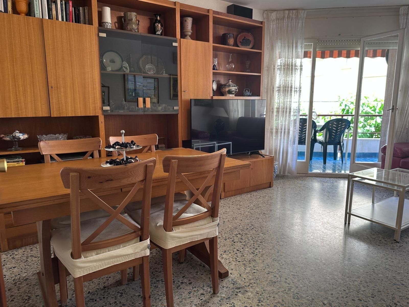 Una sala de estar con una mesa y sillas y un televisor.