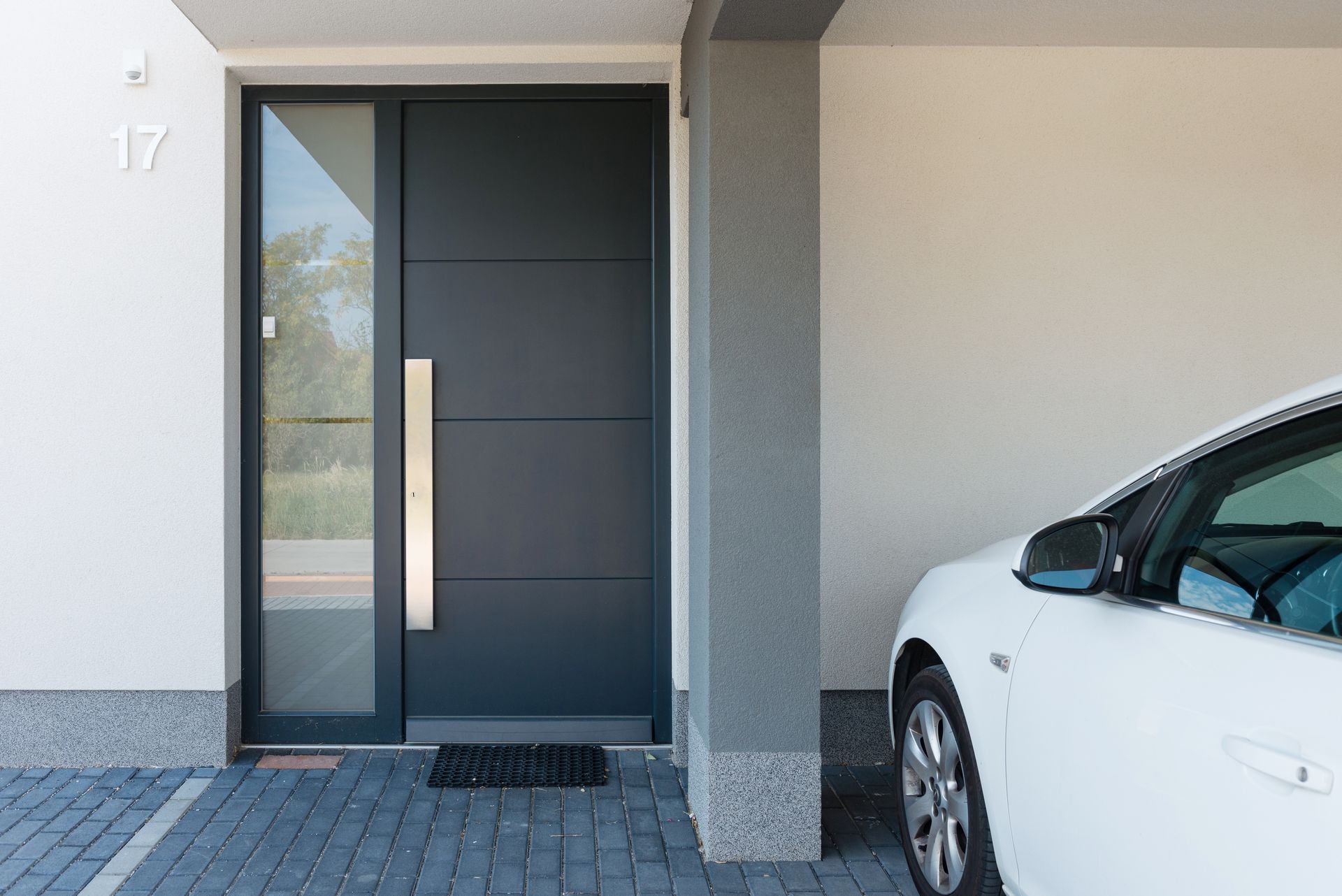 Porte d'entrée en PVC avec une partie vitrée et une voiture blanche