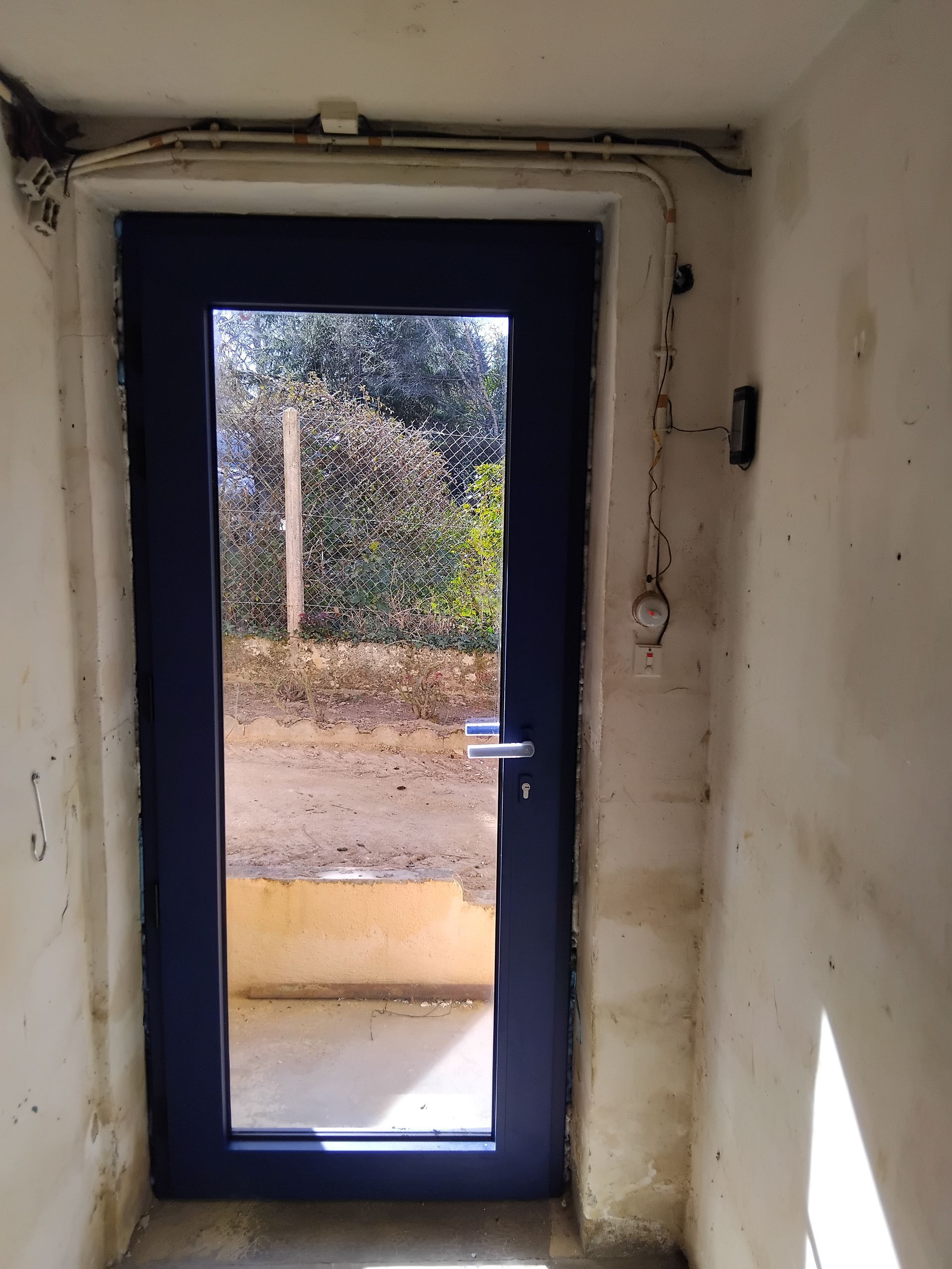 Porte d'entrée noire avec une grande partie vitrée