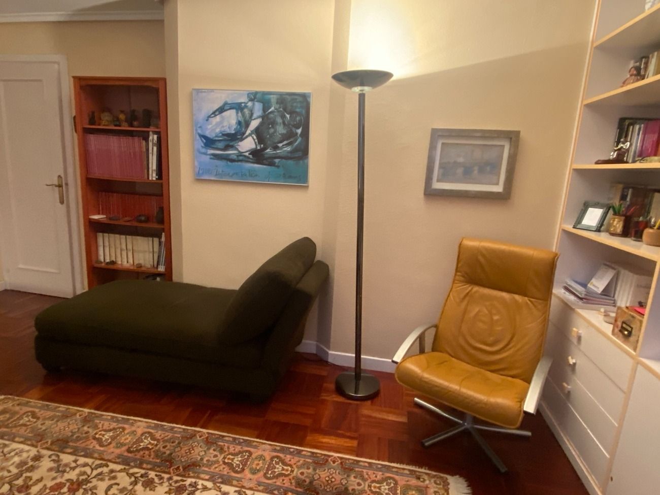 Una sala de estar con una silla y una tumbona.