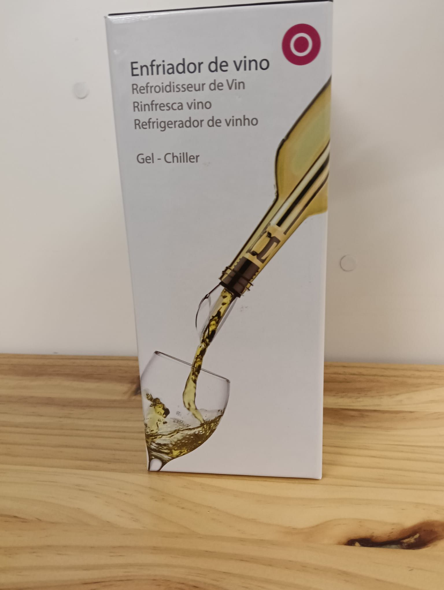 Nevera para vino con una botella vertiéndose en una copa sobre una superficie de madera.
