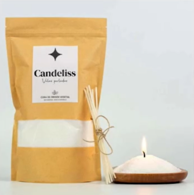 Bolsa amarilla para velas con varillas y una vela blanca encendida sobre un soporte de madera.