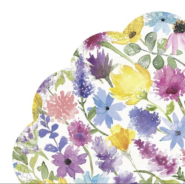 Estampado floral en acuarela con flores moradas, amarillas, rosas y azules sobre un fondo blanco.