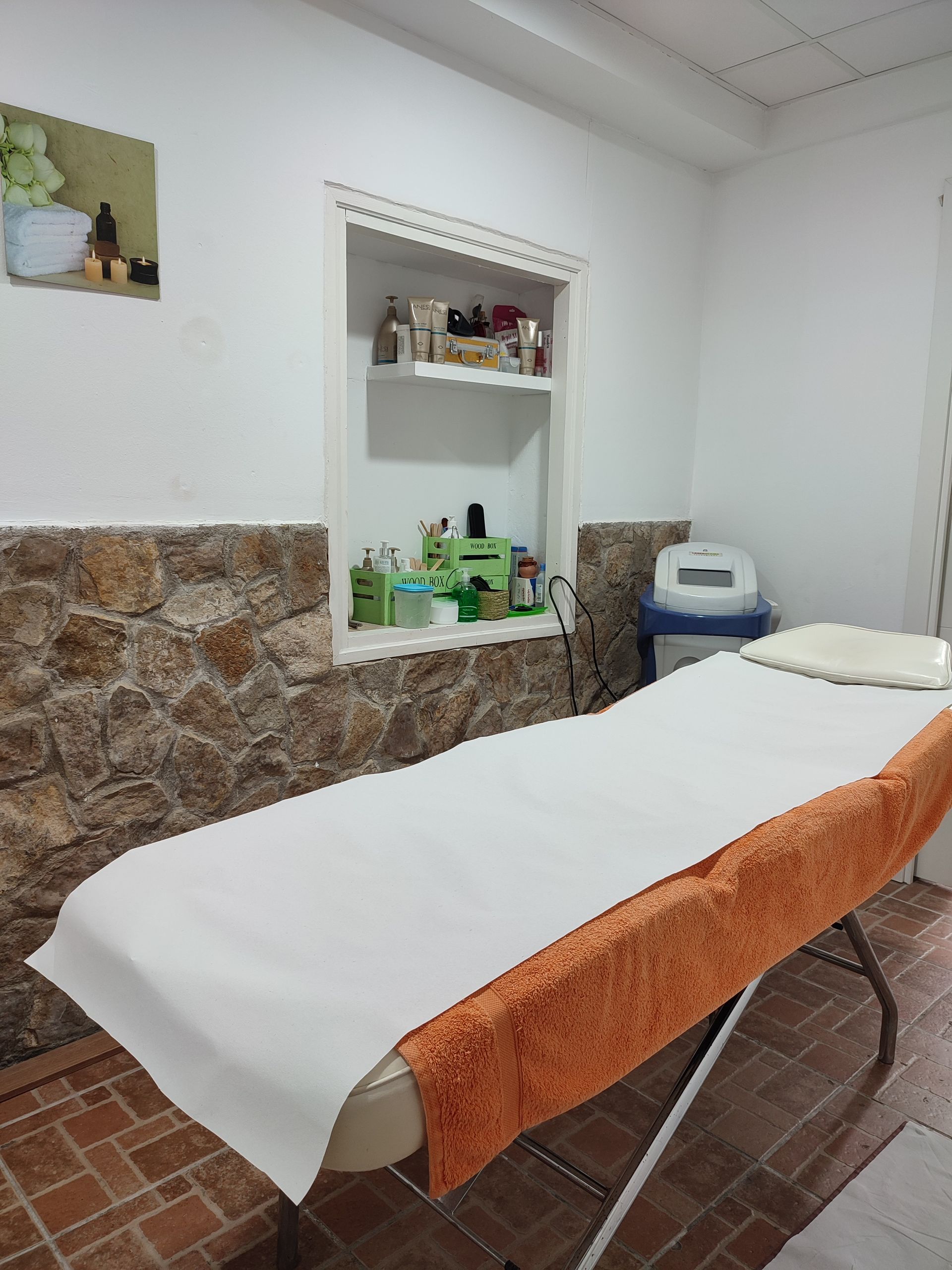 Una mesa de masaje con una toalla naranja encima.