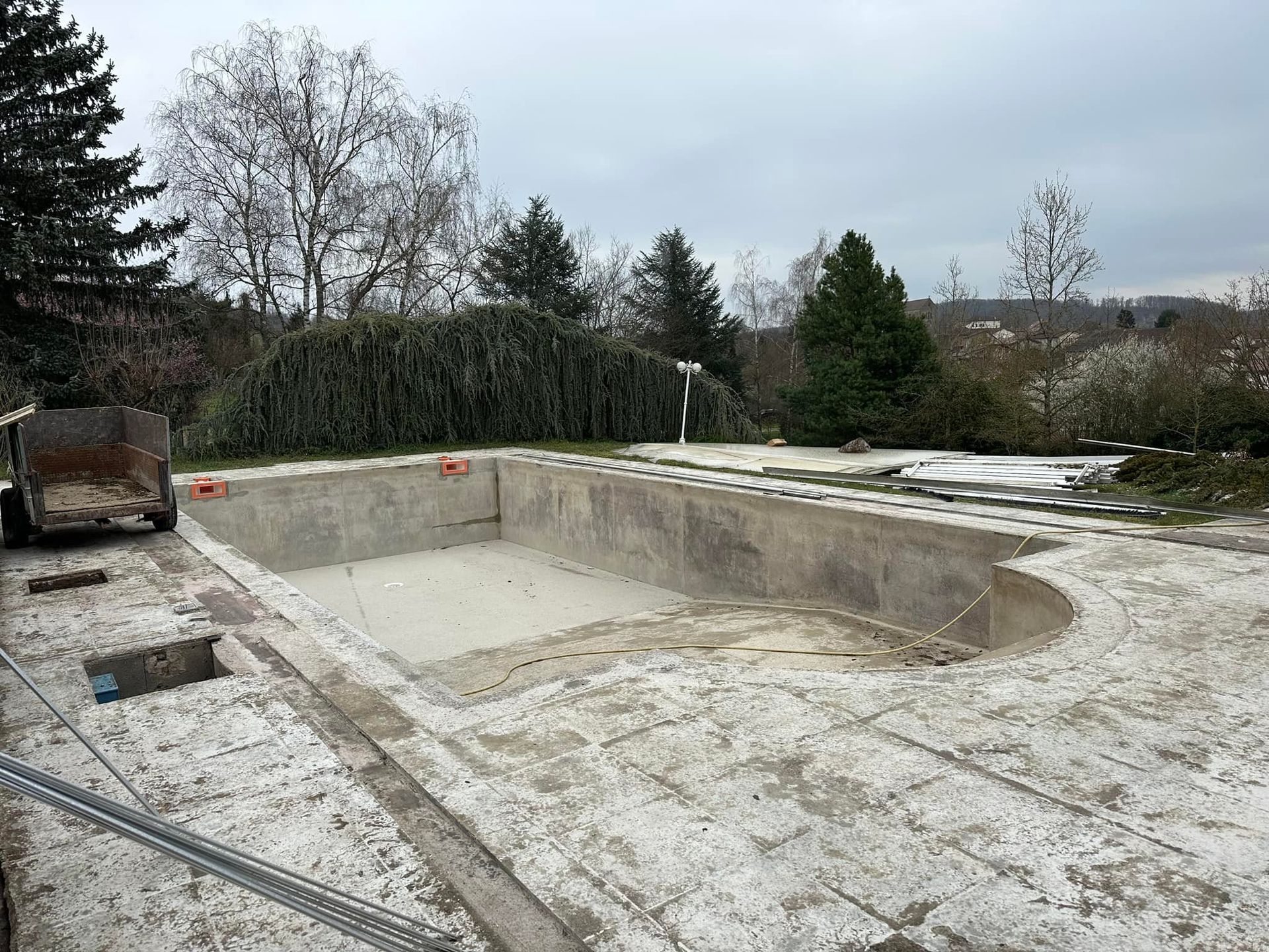 Piscine en béton vide en construction par temps nuageux.