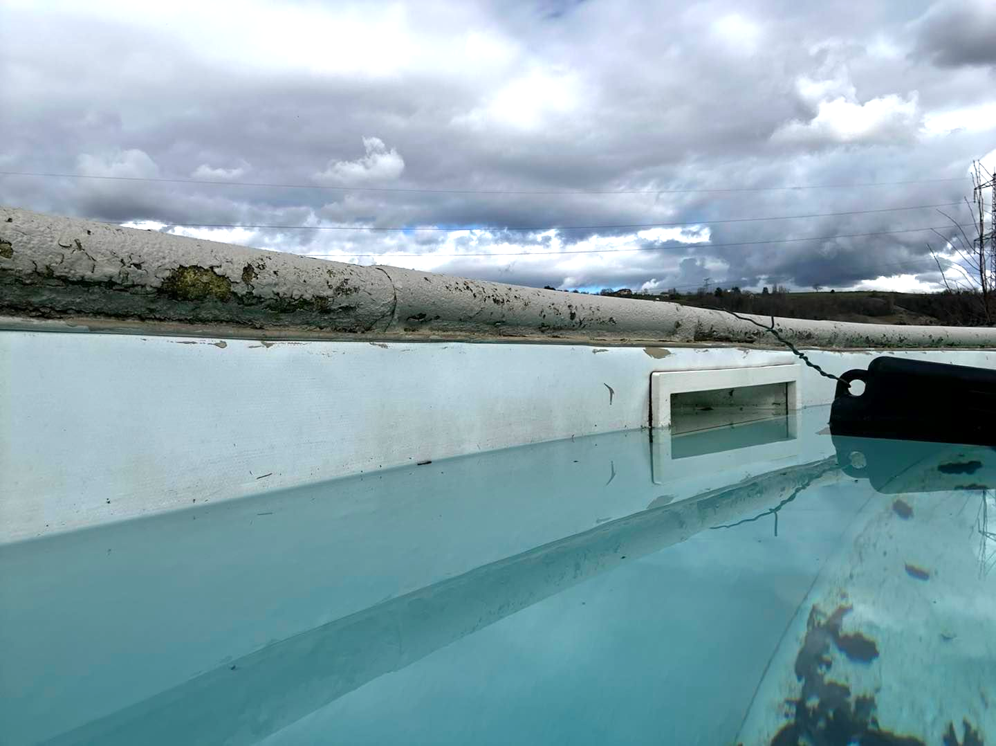 Vue rapprochée d'une piscine sale et son système d'évacuation