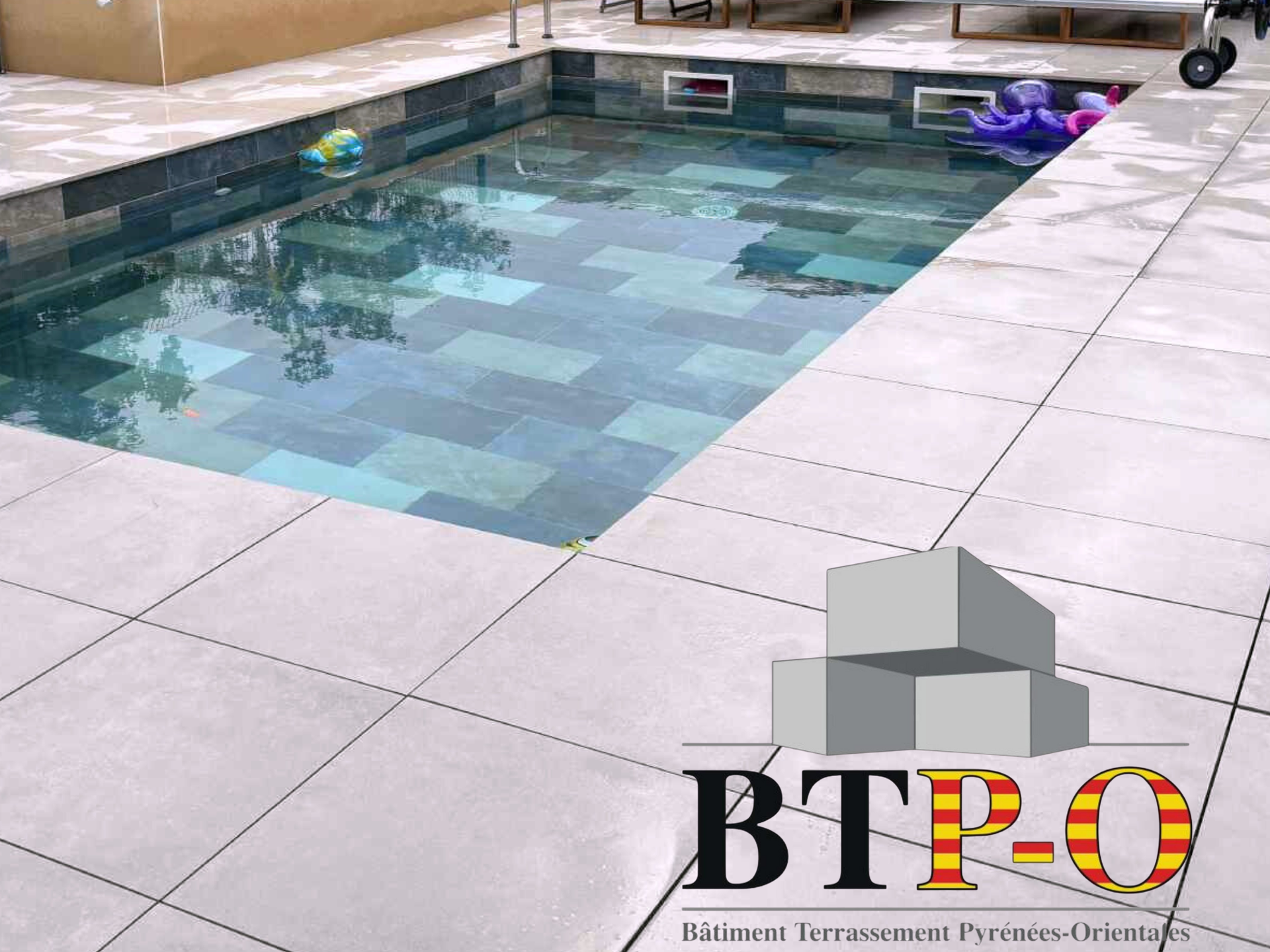 Une piscine et des dalles autour