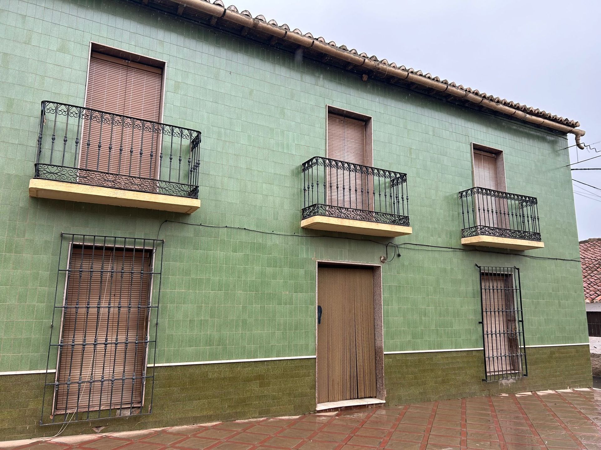 Casa moderna con piscina y terraza; cielo azul y exterior soleado.