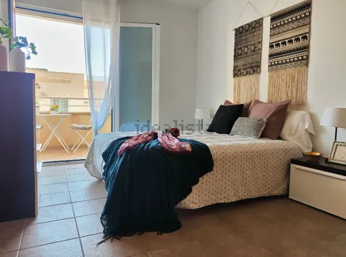 Dormitorio con cama, balcón y adornos de pared.