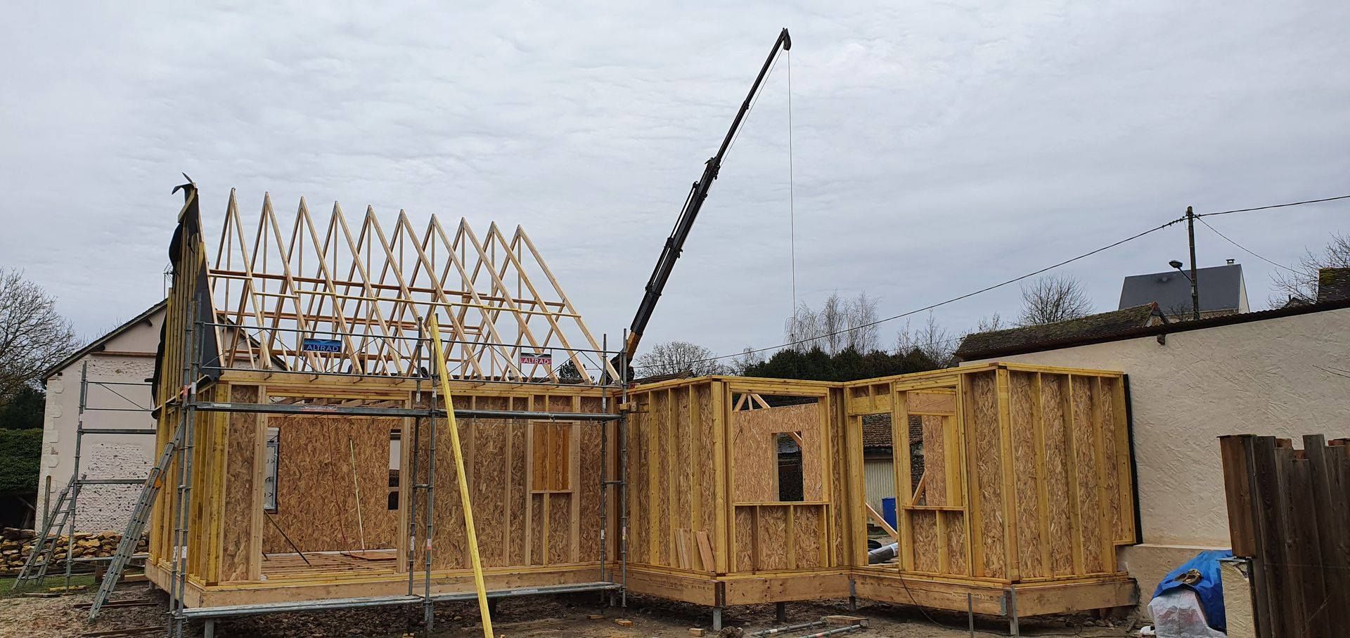 Construction d'une maison en bois avec une grue