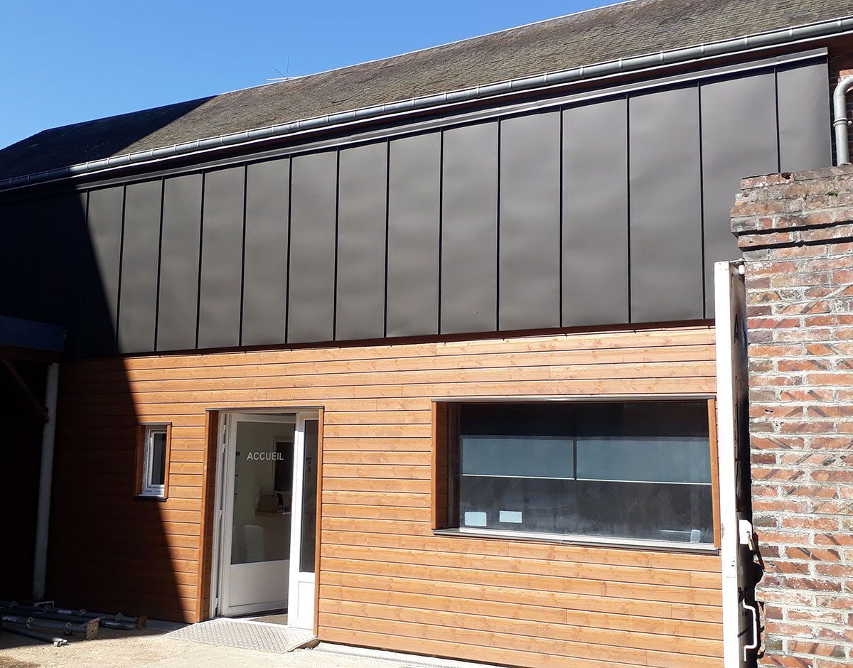 Entrée d'un bâtiment avec façade en bardage en bois