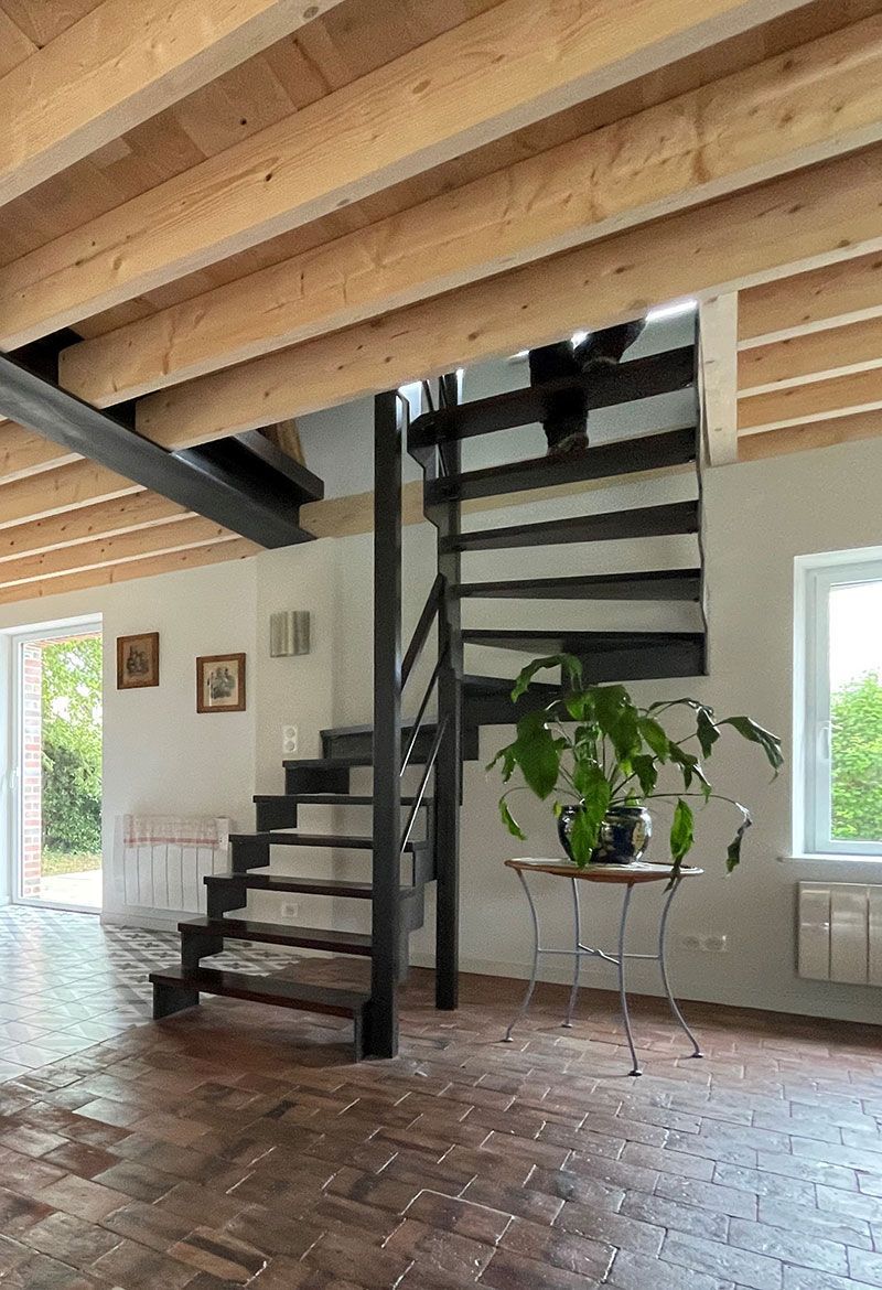Escalier en bois et en métal dans une maison avec des tomettes