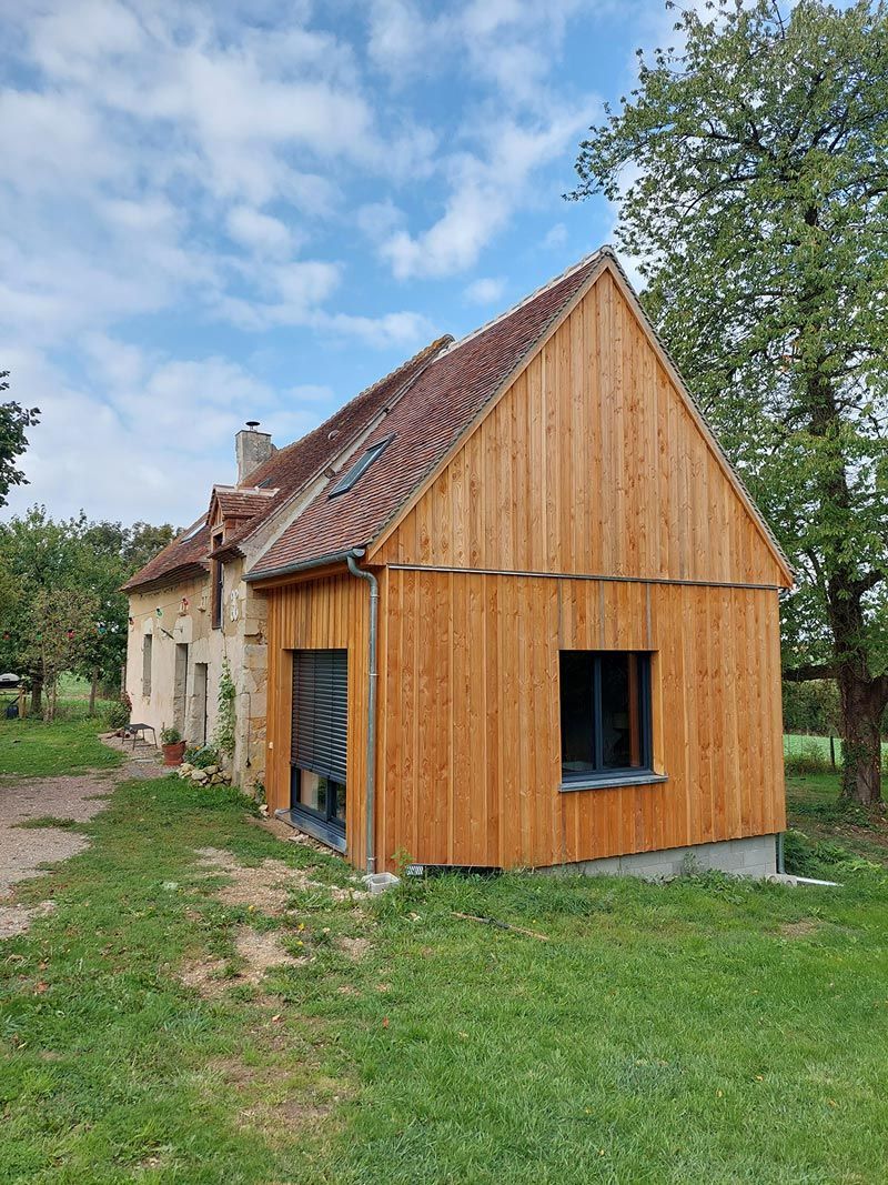 Maison avec une extension en bois et une autre partie en pierre
