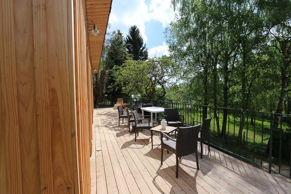 Maison en bois avec terrasse et salon de jardin