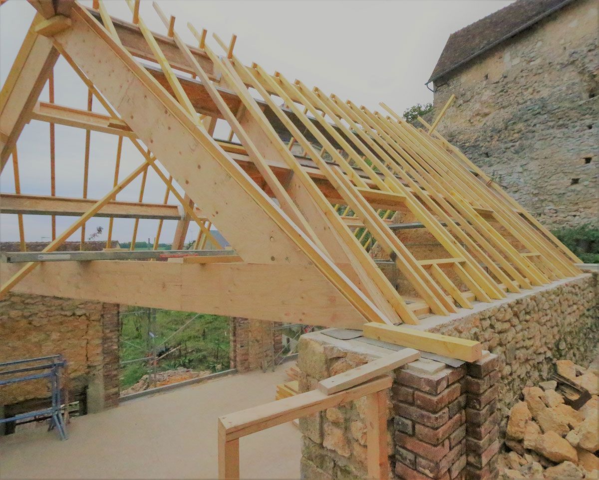 Maison en pierre et en brique en cours de rénovation de toiture