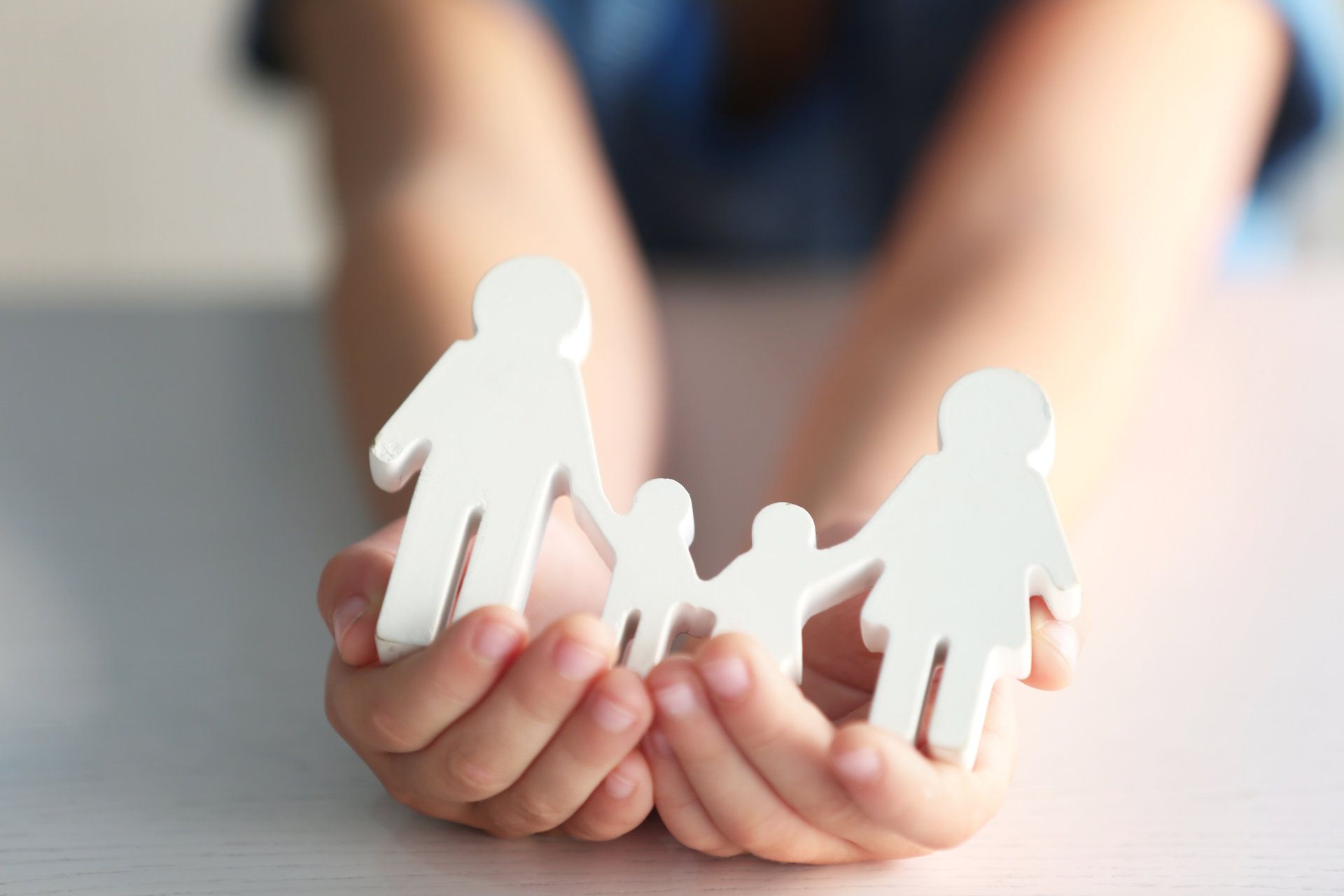eine Person hält eine Familie in ihren Händen