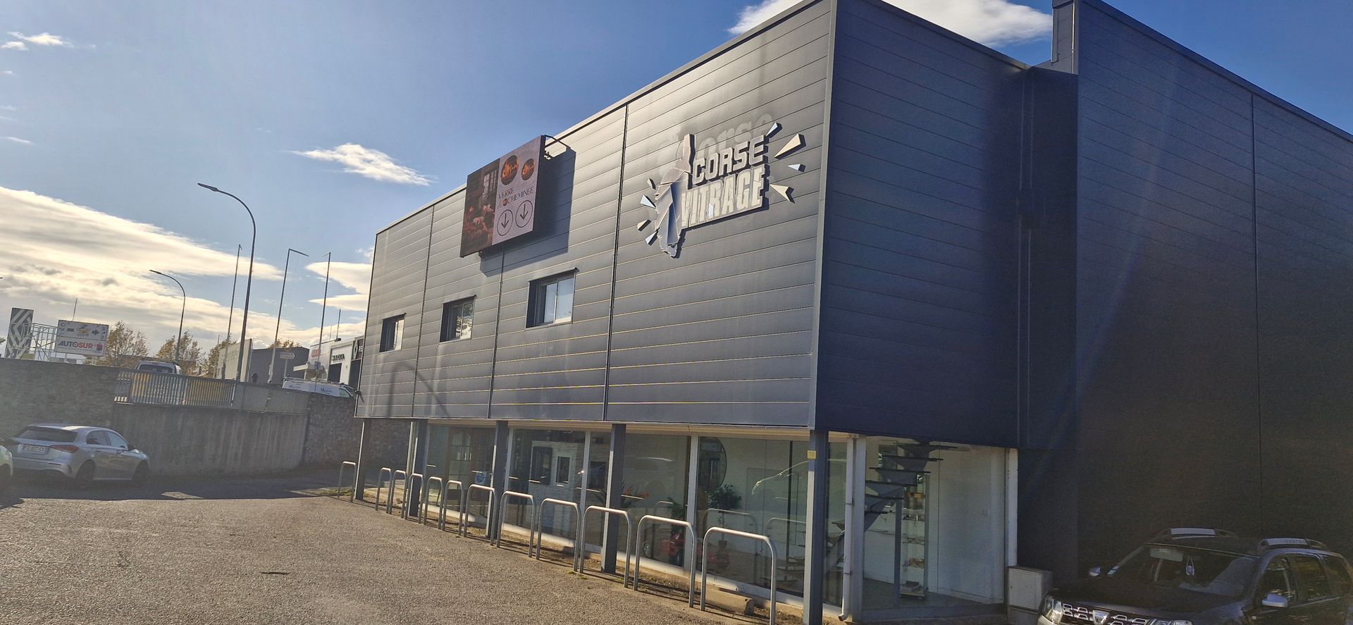 Façade de bâtiment professionnel avec vitrages extérieurs et menuiseries intégrées en aluminium.