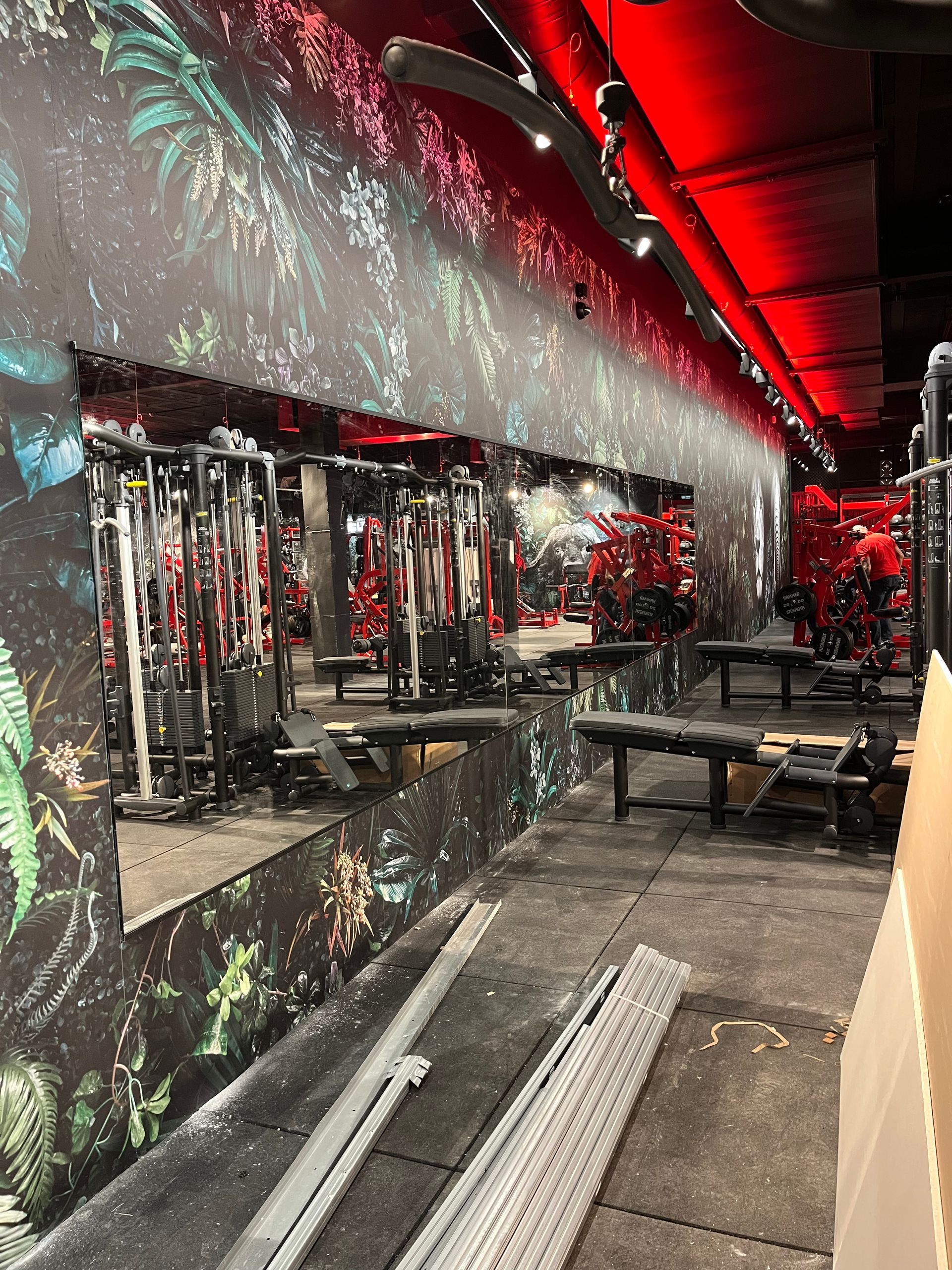 Intérieur d'une salle de sport avec équipements, miroirs et éclairage