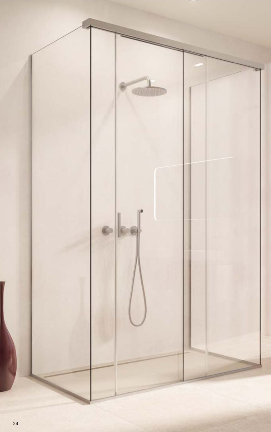 Cabine de douche en verre avec robinetterie argentée contre un mur blanc