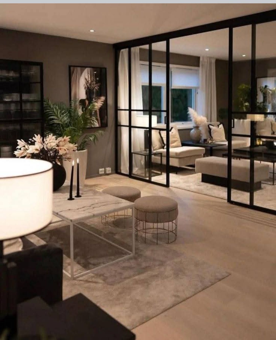 Salon élégant avec une paroi vitrée à cadre noir