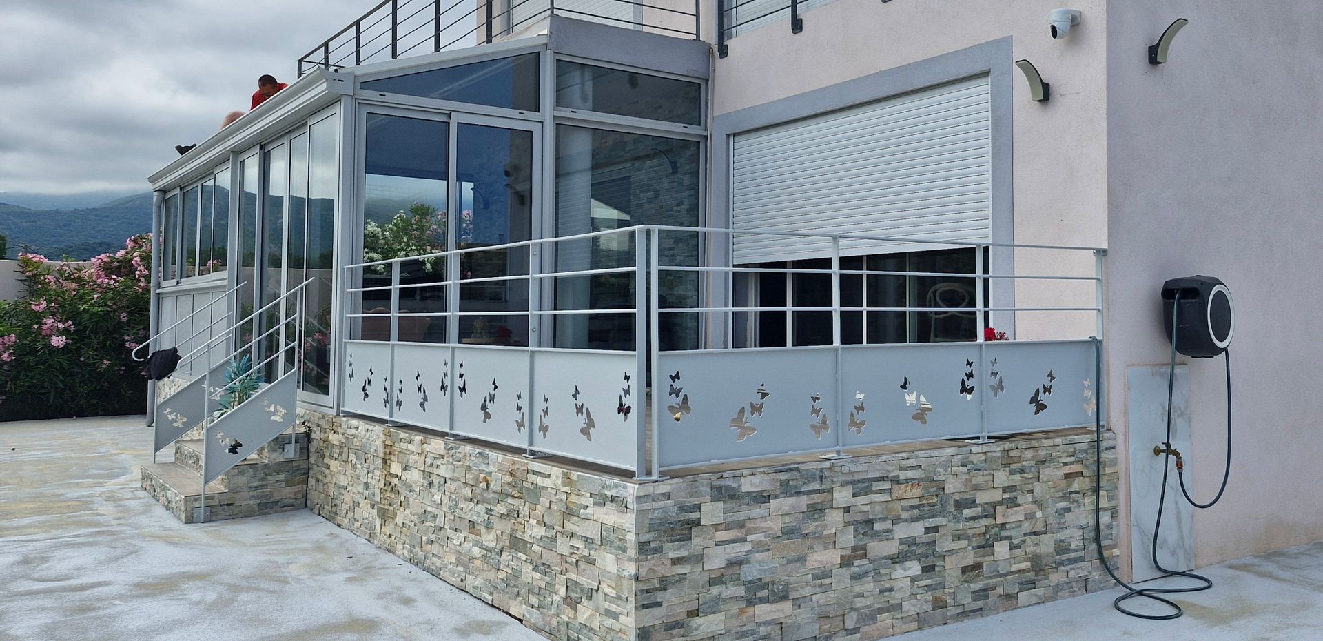 Un bâtiment moderne avec une véranda et une terrasse avec garde-corps en métal ajouré