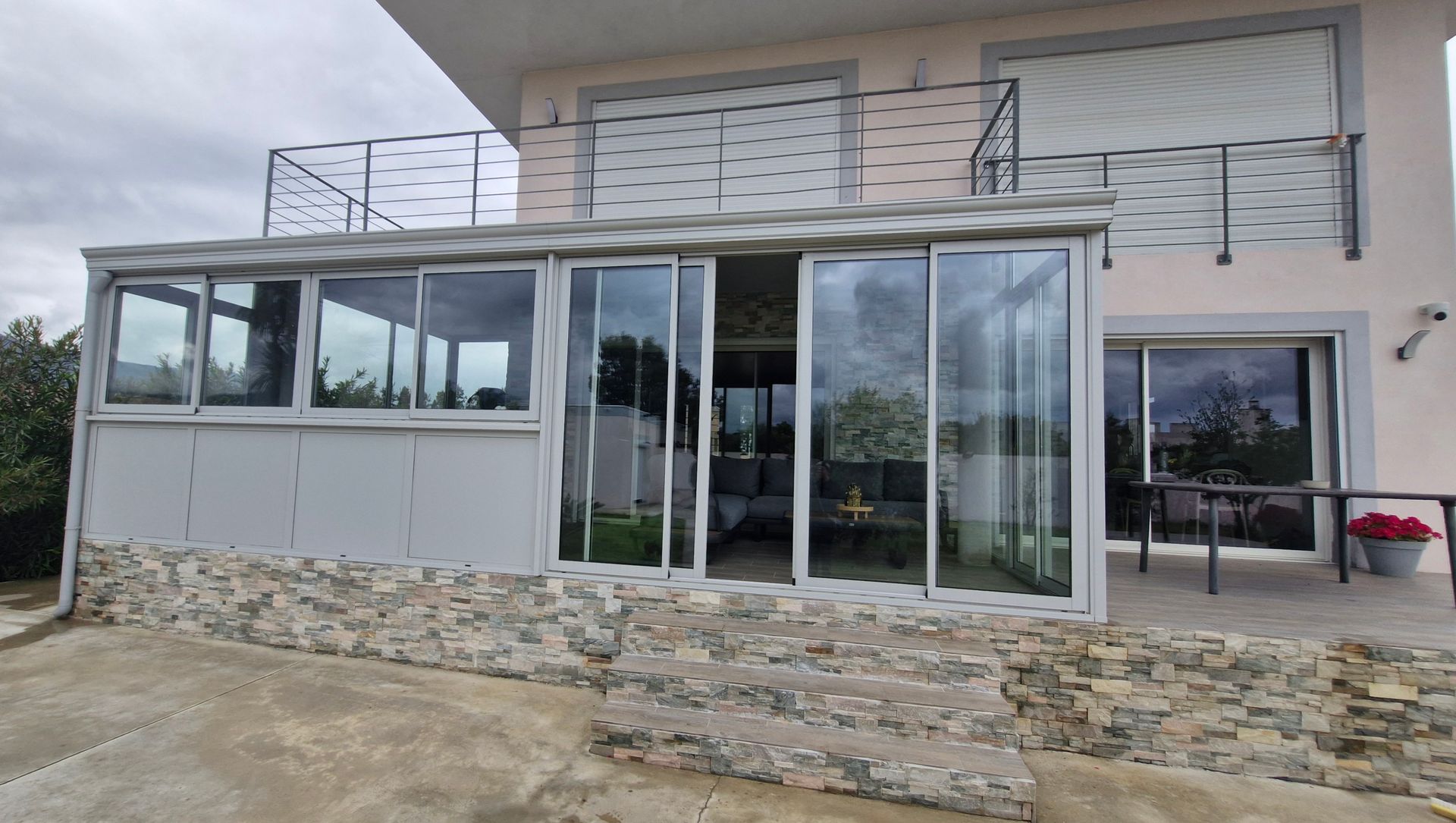 Véranda donnant sur une terrasse, balcon à l'étage avec garde-corps