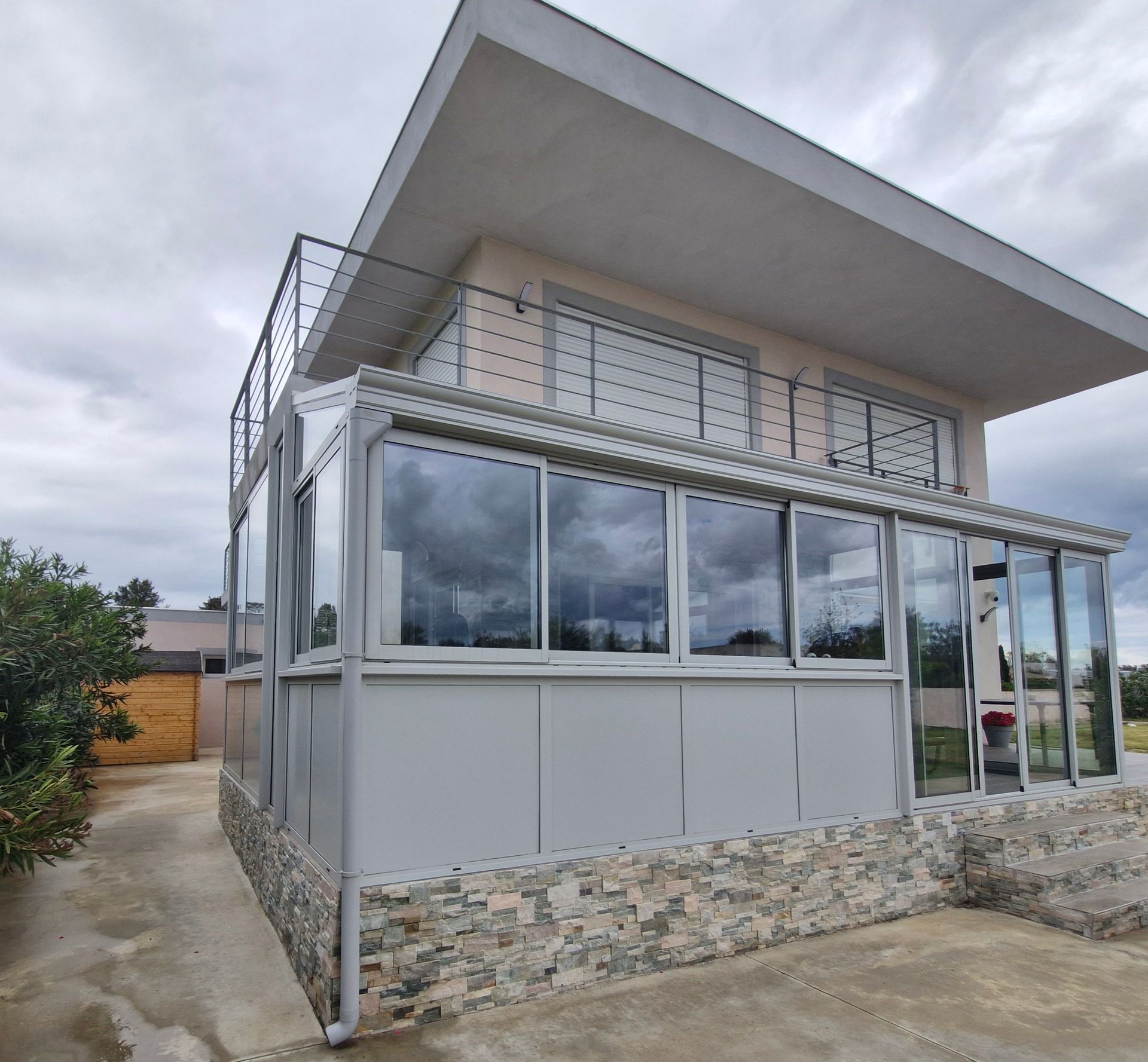 Maison moderne à deux étages avec une véranda vitrée