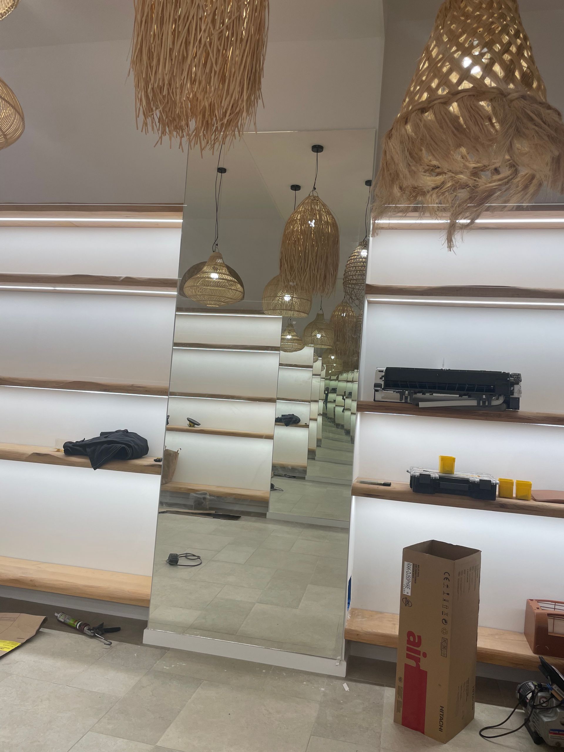 Intérieur reflétant un miroir, avec étagères, suspensions lumineuses et boîte en carton