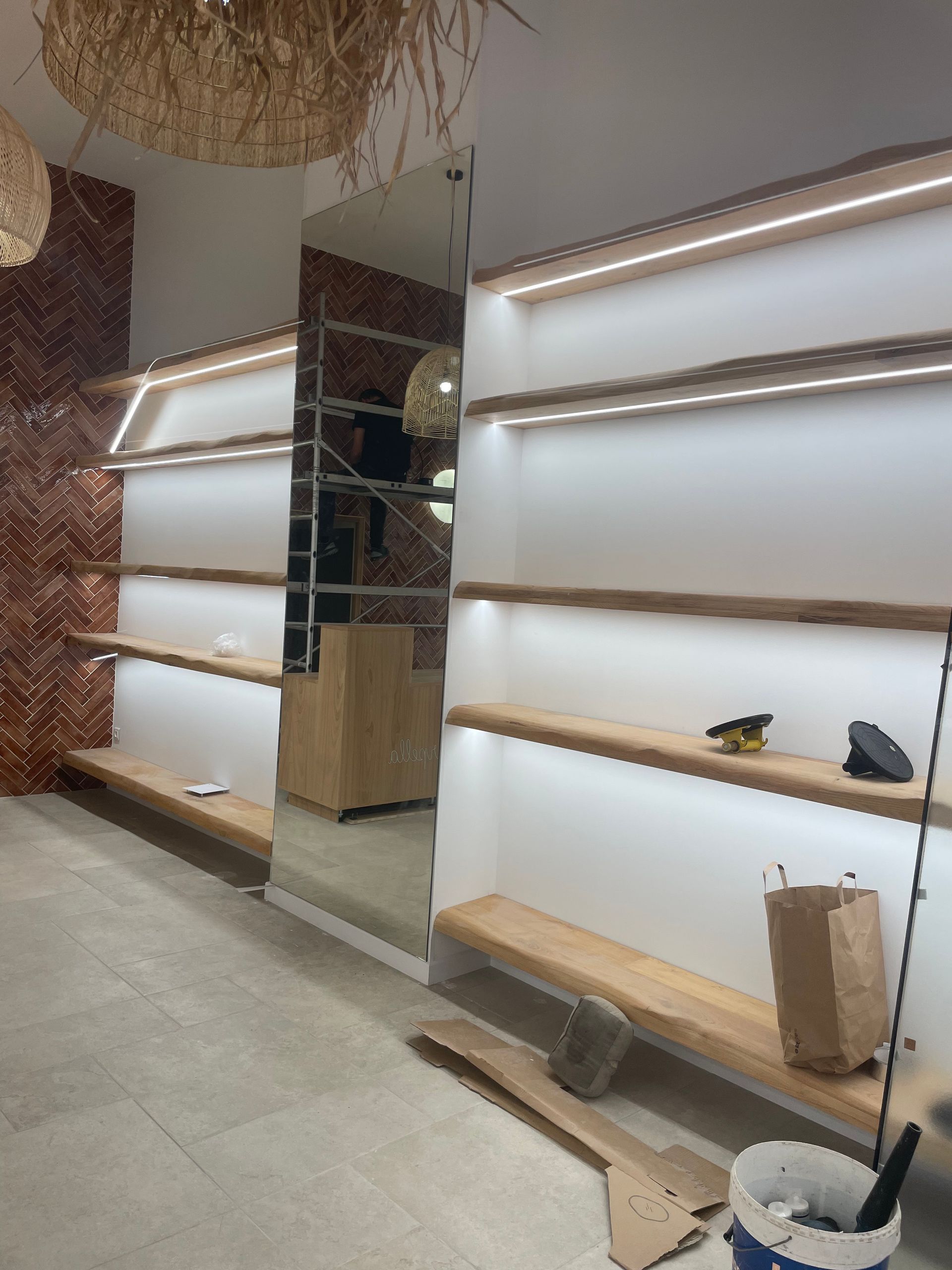 Étagères en bois avec éclairage LED dans un magasin, grand miroir reflétant l'intérieur