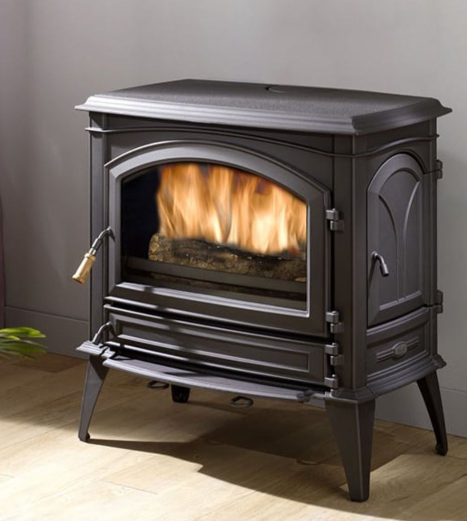 Poêle à bois en fonte noire, avec des flammes visibles à travers sa vitre
