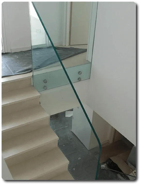 Garde‑corps d’escalier en verre sécurisé fixé sur structure intérieure avec marches en pierre.