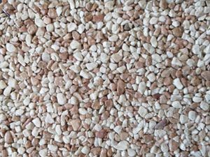 Vue rapprochée d'une surface texturée composée de petits cailloux beiges et brun clair.