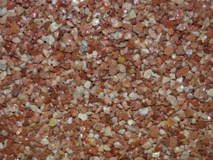 Gros plan sur du gravier rouge et beige utilisé à des fins décoratives ou d'aménagement paysager.