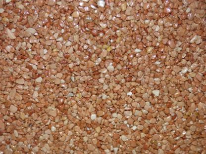 Petits graviers brun rougeâtre, serrés, créant une surface texturée.