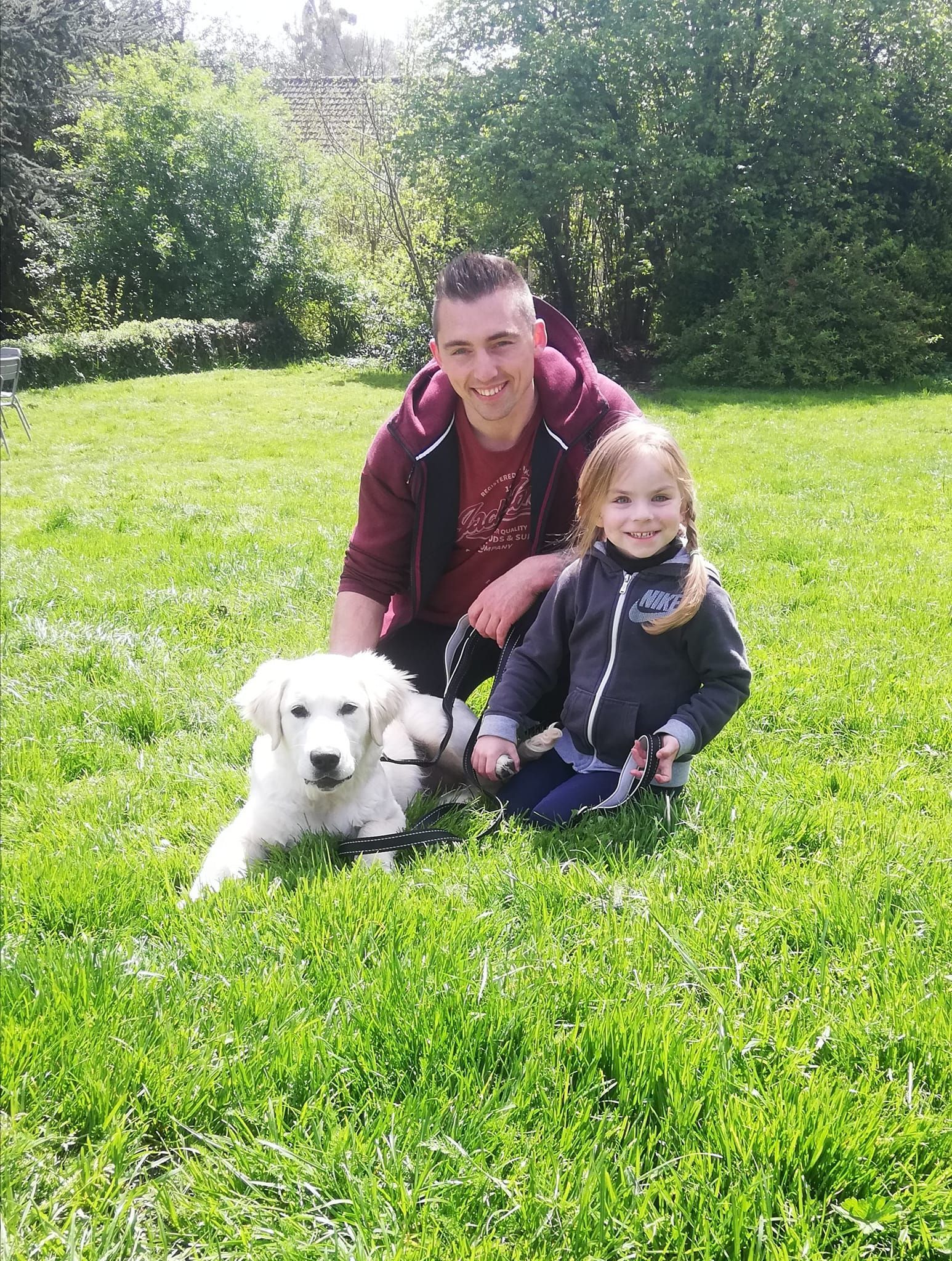 Homme et petite fille avec leur chiot blanc