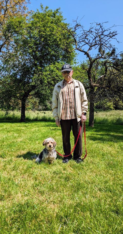 Homme avec une casquette qui tient son chien en laisse