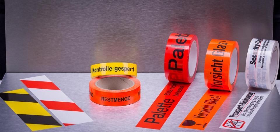 GUNTHER BLUM GmbH – Person sitzt umgeben von Pappkartons auf einer Couch und bedient einen Laptop