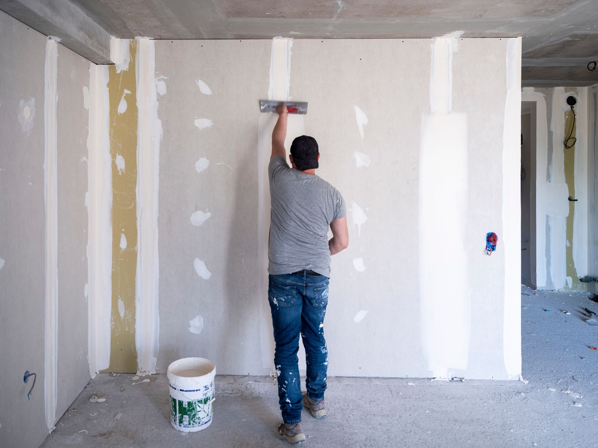Intérieur d'un bâtiment en construction, montrant une ossature murale en bois avec isolation.