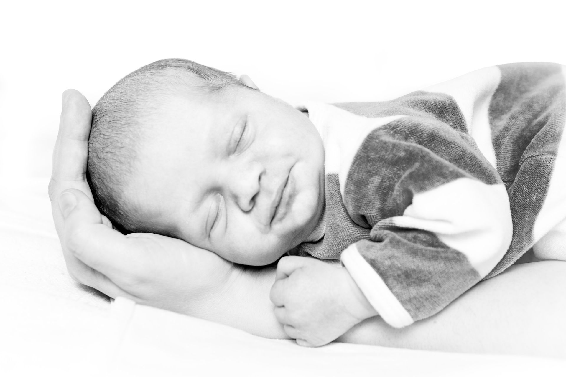 Bébé qui dort dans une main