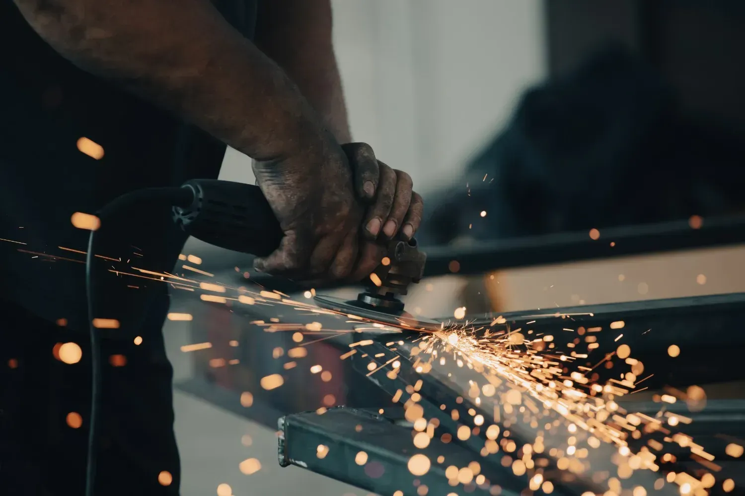 Persona usando una amoladora, saltan chispas.