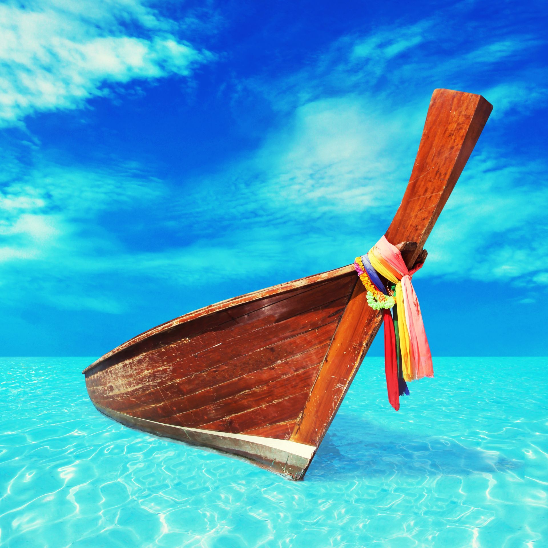 A boat is floating in the ocean with a blue sky in the background