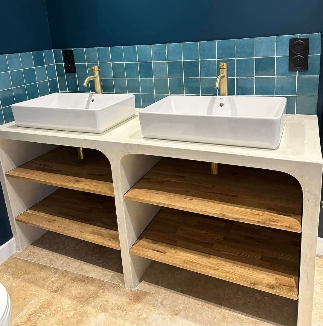 Deux lavabos blancs et étagères en bois.